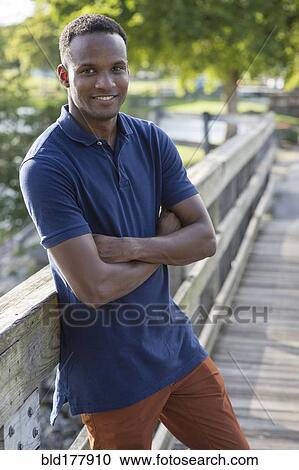 Stock Image - Black man smiling outdoors. Fotosearch