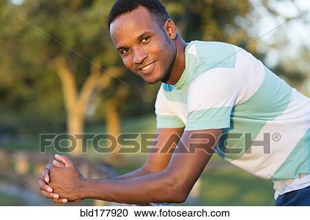 Stock Image - Black man smiling outdoors. Fotosearch