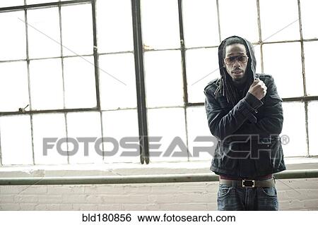 Stock Photograph - Black man standing at window. Fotosearch