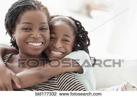 Stock Image - Black mother and daughter hugging. Fotosearch