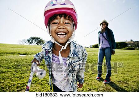 Stock Image - Black mother and daughter playing in park. Fotosearch
