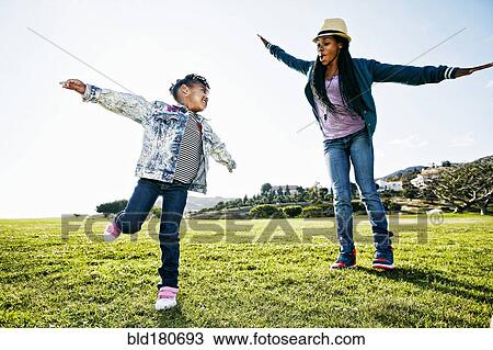 Stock Image - Black mother and daughter playing in park. Fotosearch