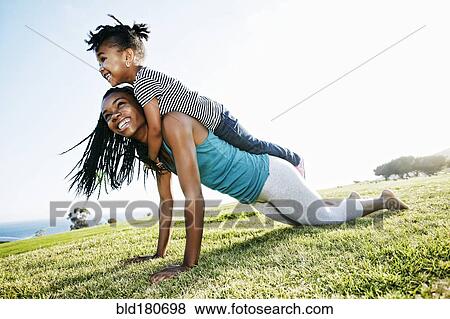 Stock Photo - Black mother and daughter practicing yoga. Fotosearch