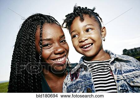Picture - Black mother and daughter smiling outdoors. Fotosearch