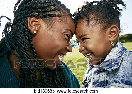 Stock Photography - Black mother and daughter smiling outdoors. Fotosearch