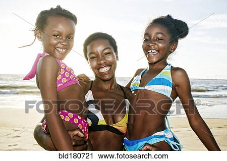 Black mother holding daughters on beach View Large Photo Image Stock Image - Black mother holding daughters on beach. Fotosearch