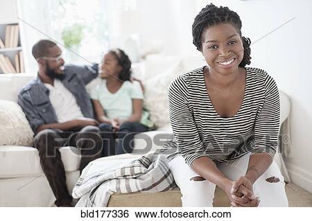 Stock Photograph - Black mother sitting in living room. Fotosearch
