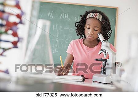 Stock Photography - Black student performing experiment in science class. Fotosearch