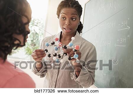 Stock Photograph - Black teacher showing molecular model to students. Fotosearch