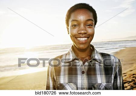 Stock Photograph - Black woman smiling on beach. Fotosearch