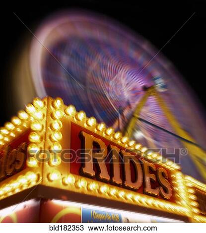 Stock Image - Blurred view of ferris wheel at amusement park. Fotosearch