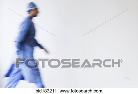 Stock Image - Blurred view of mixed race surgeon walking. Fotosearch