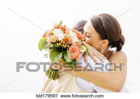 Stock Photo - Bride and groom hugging in outdoor wedding. Fotosearch