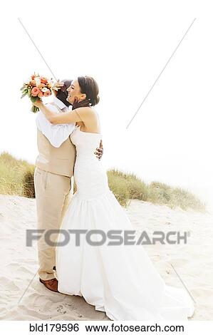 Bride and groom hugging in outdoor wedding View Large Photo Image Stock Photograph - Bride and groom hugging in outdoor wedding. Fotosearch