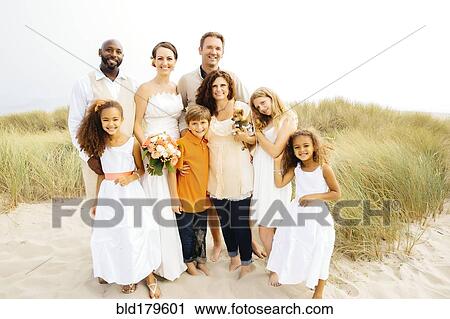 Stock Image - Bride and groom smiling with family at wedding. Fotosearch