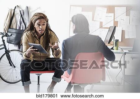 Stock Image - Business people talking in office. Fotosearch