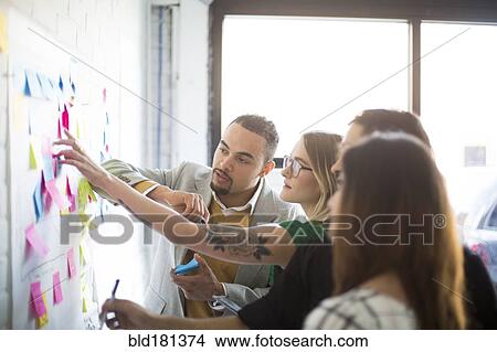 Picture - Business people using adhesive notes in office. Fotosearch