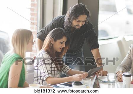 Stock Image - Business people using digital tablet in office. Fotosearch
