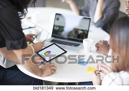 Business people using digital tablet in office meeting View Large Photo Image Stock Photo - Business people using digital tablet in office meeting. Fotosearch