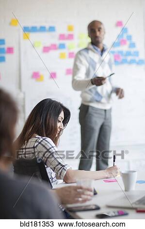 Business people writing notes in office meeting View Large Photo Image Stock Image - Business people writing notes in office meeting. Fotosearch