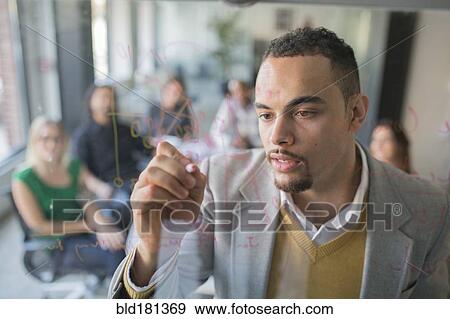 Businessman drawing graph on glass wall in office View Large Photo Image Stock Photo - Businessman drawing graph on glass wall in office. Fotosearch