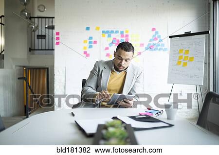 Businessman using digital tablet in office View Large Photo Image Stock Image - Businessman using digital tablet in office. Fotosearch