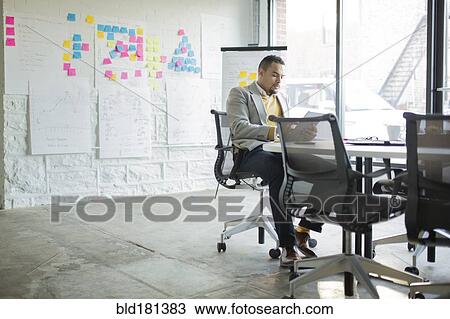 Stock Image - Businessman using digital tablet in office. Fotosearch