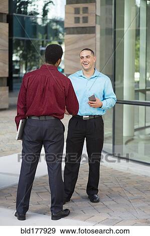 Stock Photo - Businessmen shaking hands outdoors. Fotosearch