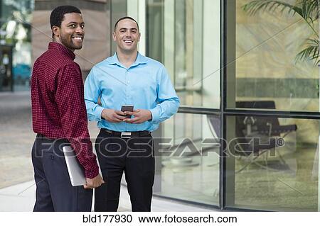 Businessmen smiling outdoors View Large Photo Image Stock Image - Businessmen smiling outdoors. Fotosearch