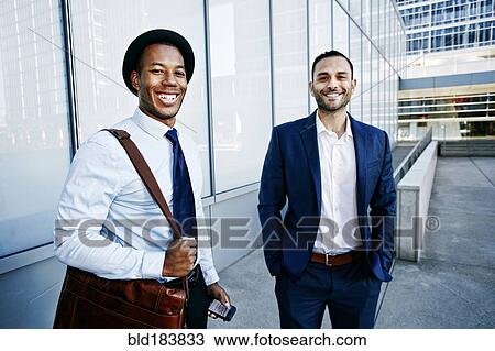 Businessmen smiling outside office building View Large Photo Image Stock Image - Businessmen smiling outside office building. Fotosearch