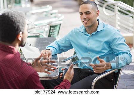 Picture - Businessmen talking in cafe. Fotosearch