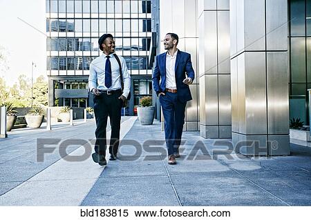 Stock Photography - Businessmen talking outside office building. Fotosearch