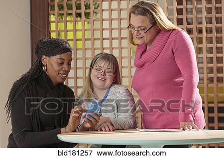 Stock Photo - Businesswoman using cell phone in office. Fotosearch
