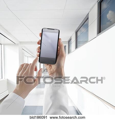 Businesswoman using cell phone in white corridor View Large Photo Image Stock Image - Businesswoman using cell phone in white corridor. Fotosearch