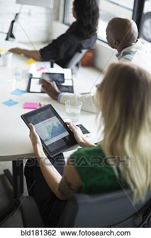 Businesswoman using digital tablet in office meeting View Large Photo Image Stock Image - Businesswoman using digital tablet in office meeting. Fotosearch