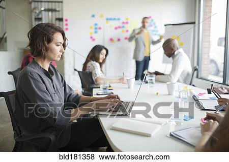 Businesswoman using laptop in office meeting View Large Photo Image Stock Photo - Businesswoman using laptop in office meeting. Fotosearch