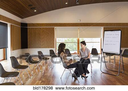 Businesswomen talking in meeting room View Large Photo Image Stock Photo - Businesswomen talking in meeting room. Fotosearch