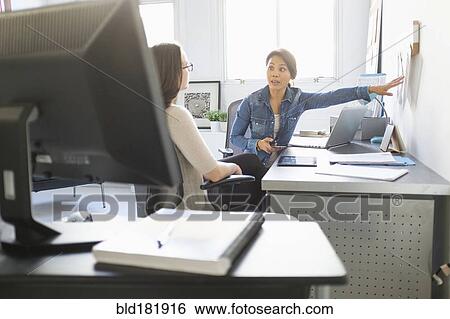 Businesswomen talking in office View Large Photo Image Stock Photograph - Businesswomen talking in office. Fotosearch