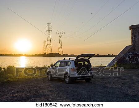 Stock Image - Car parked on rural lake shore. Fotosearch