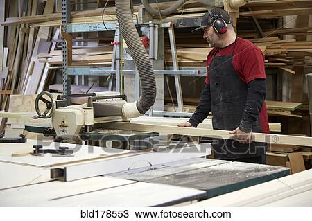 Carpenter using saw in workshop View Large Photo Image Stock Image - Carpenter using saw in workshop. Fotosearch