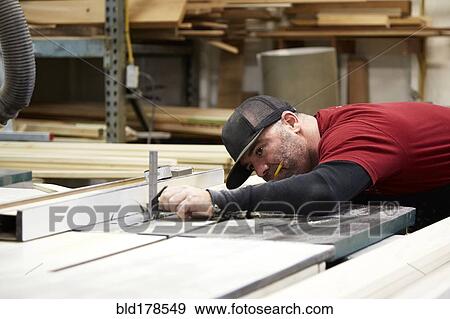 Stock Photo - Carpenter using table saw in workshop. Fotosearch