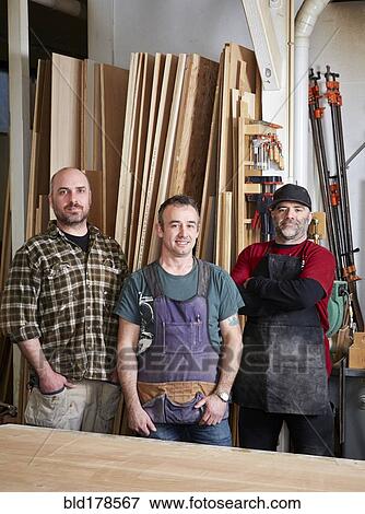 Stock Photo - Carpenters smiling in workshop. Fotosearch