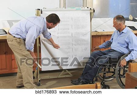 Stock Image - Caucasian architects talking in office. Fotosearch