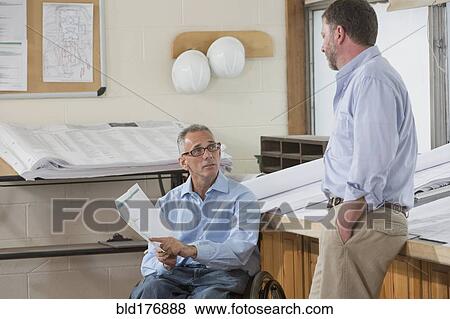 Stock Photo - Caucasian architects talking in office. Fotosearch