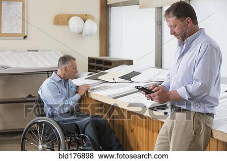 Stock Photo - Caucasian architects talking in office. Fotosearch