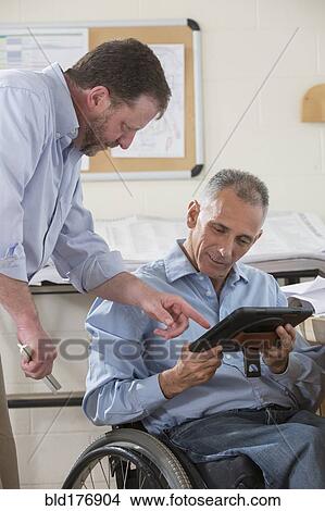 Picture - Caucasian architects using digital tablet in office. Fotosearch