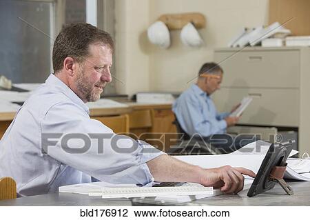 Stock Image - Caucasian architects working in office. Fotosearch