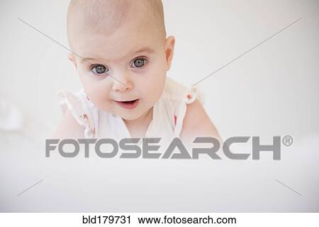 Caucasian baby girl crawling on bed View Large Photo Image Stock Image - Caucasian baby girl crawling on bed. Fotosearch