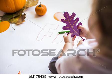 Stock Photography - Caucasian baby girl holding leaf. Fotosearch
