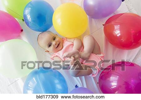 Caucasian baby girl laying in balloons View Large Photo Image Stock Photo - Caucasian baby girl laying in balloons. Fotosearch